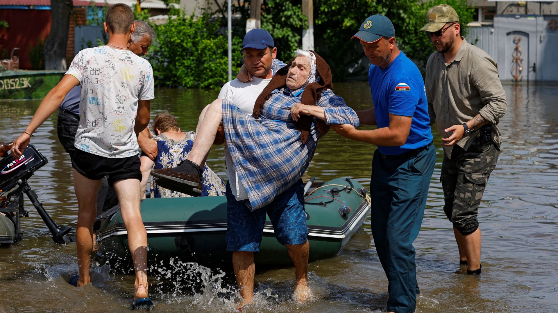 A member of Russia's emergencies ministry and a local resident carry an elderly woman during the evacuation of residents from a flooded area following the collapse of the Nova Kakhovka dam in the course of Russia-Ukraine conflict, in the town of Hola Prystan in the Kherson region, Russian-controlled Ukraine, June 8, 2023. 