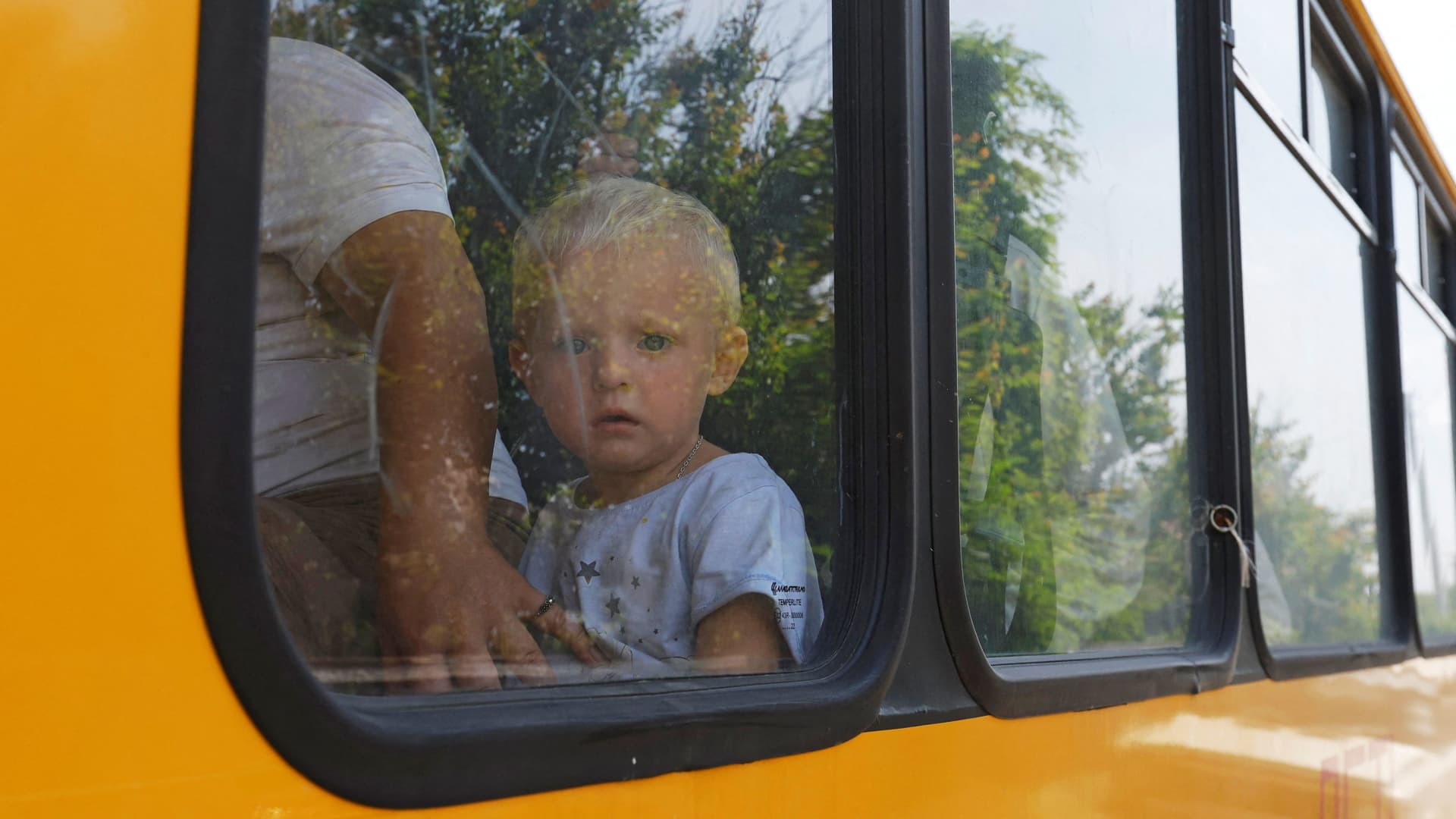 A child looks out of a bus window during an evacuation from a flooded area following the collapse of the Nova Kakhovka dam in the course of Russia-Ukraine conflict, in the town of Hola Prystan in the Kherson region, Russian-controlled Ukraine, June 8, 2023. 