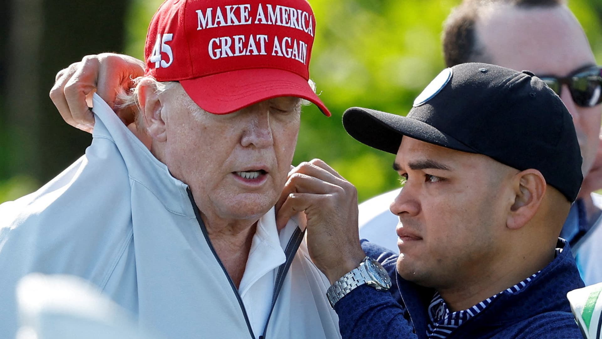Walt Nauta, personal aide to former U.S. President Donald Trump who faces charges of being Trump's co-conspirator in the alleged mishandling of classified documents, fixes Trump's collar before a LIV Golf Pro-Am golf tournament at the Trump National Golf Club in Sterling, Virginia, U.S. May 25, 2023. 