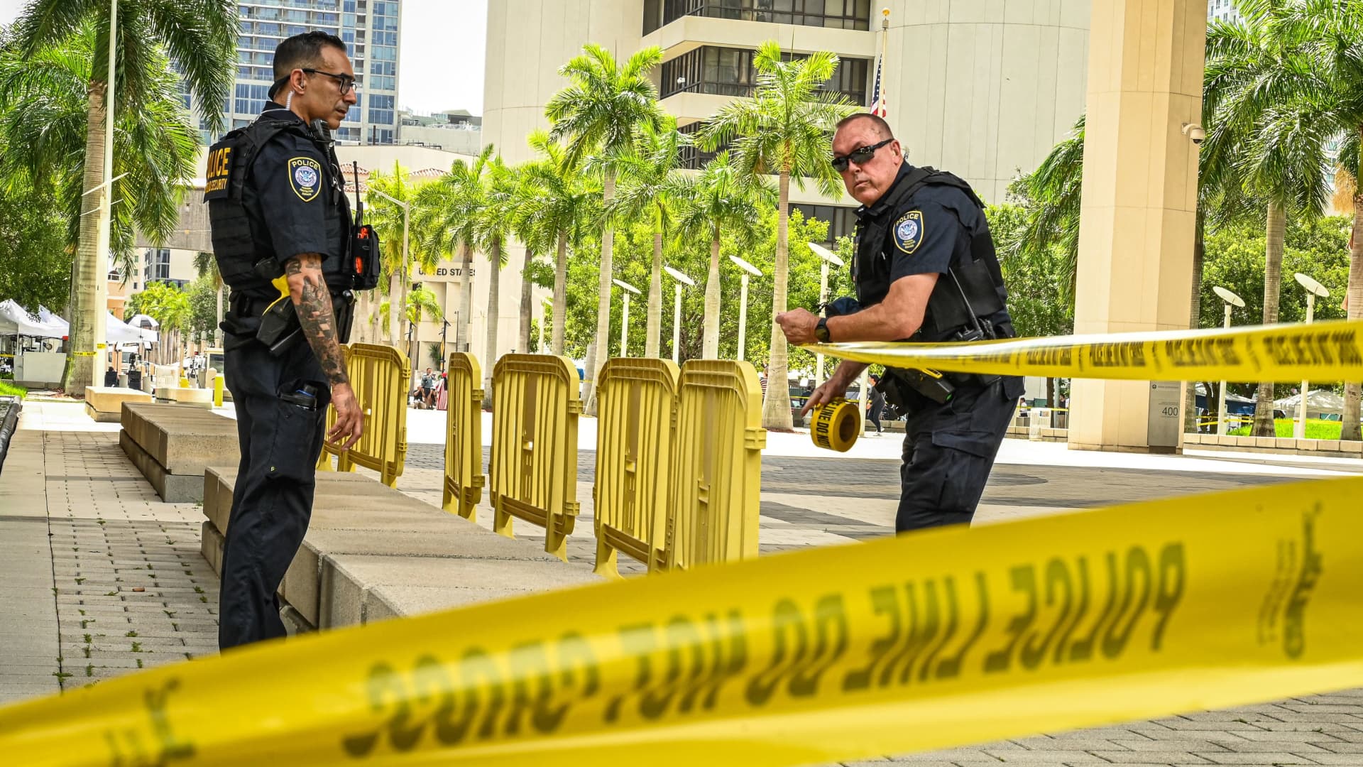 Law enforcement officers tie police tape in front of the Wilkie D. Ferguson Jr. United States Federal Courthouse in Miami, Florida, on June 12, 2023.