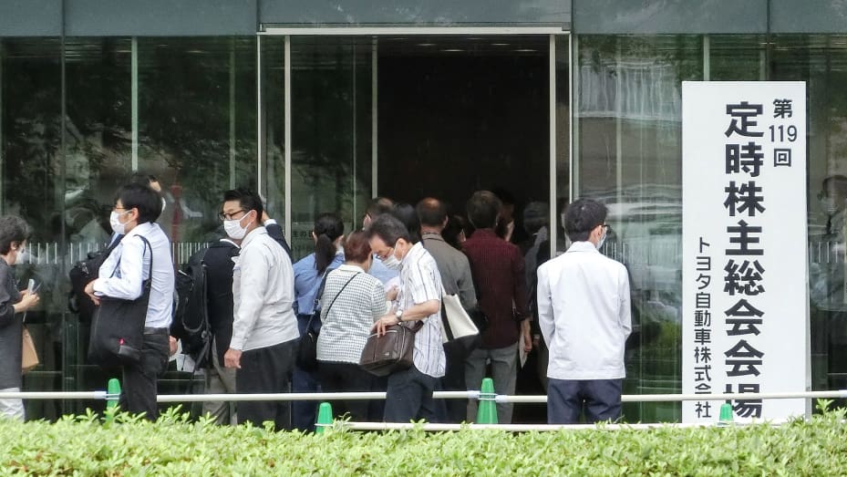 People arrive to attend an annual shareholders' meeting for Toyota Motor in the city of Toyota, Aichi Prefecture on June 14, 2023. Toyota is under pressure from large institutional investors for chairman Akio Toyoda to step down over his lukewarm embrace of electric vehicles.