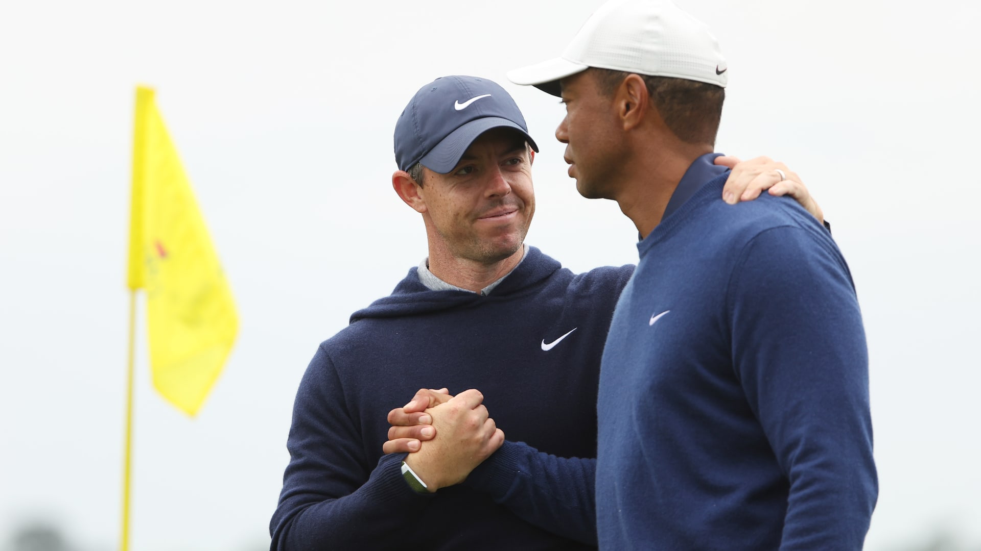 Rory McIlroy shakes hands with Tiger Woods on the 18th green after they completed a practice round prior to the 2023 Masters Tournament at Augusta National Golf Club in Augusta, Georgia, April 3, 2023.