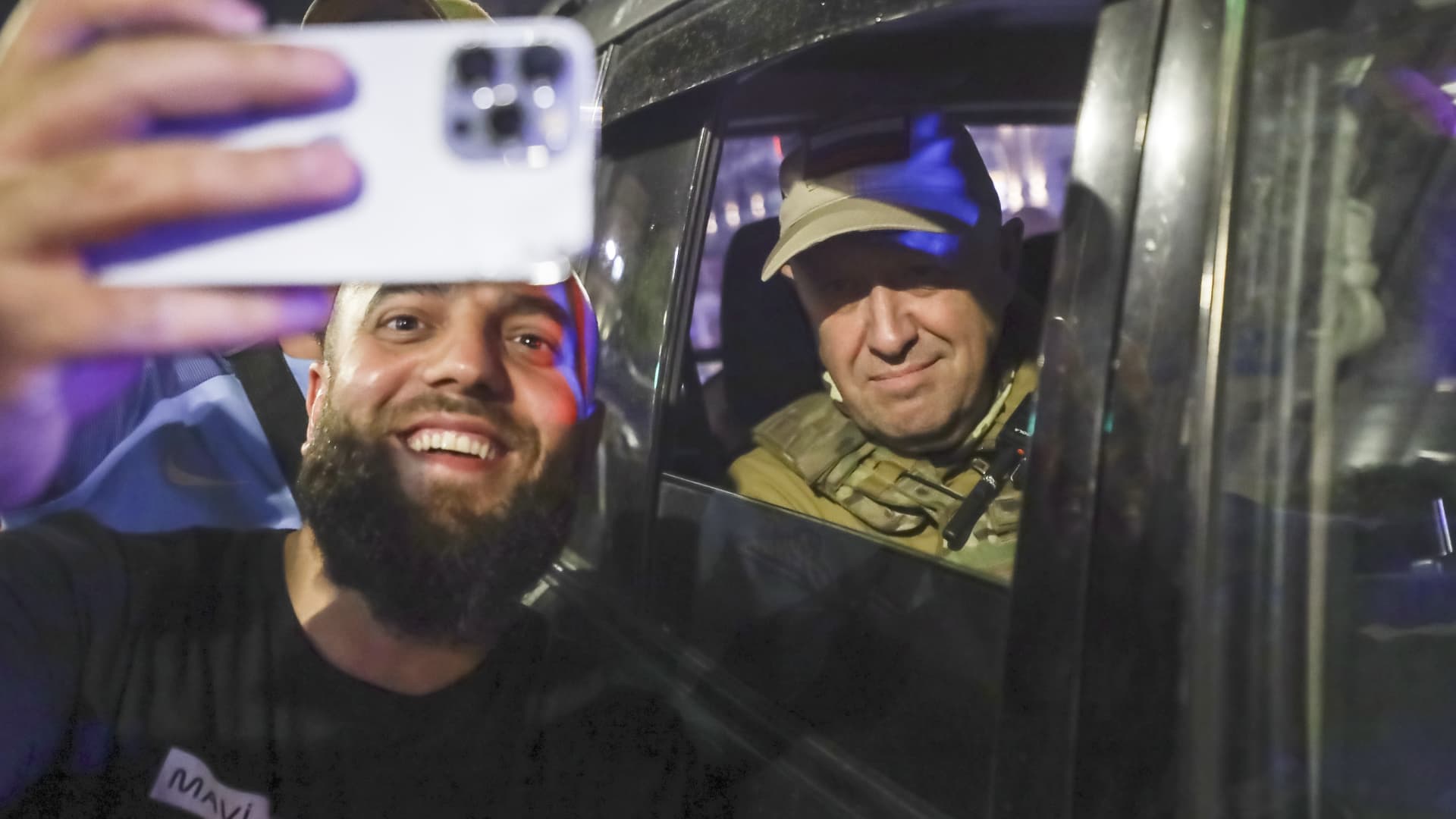 Yevgeny Prigozhin, the owner of the Wagner Group military company, right, sits inside a military vehicle posing for a selfie photo with a local civilian on a street in Rostov-on-Don, Russia, Saturday, June 24, 2023, prior to leaving an area of the headquarters of the Southern Military District.