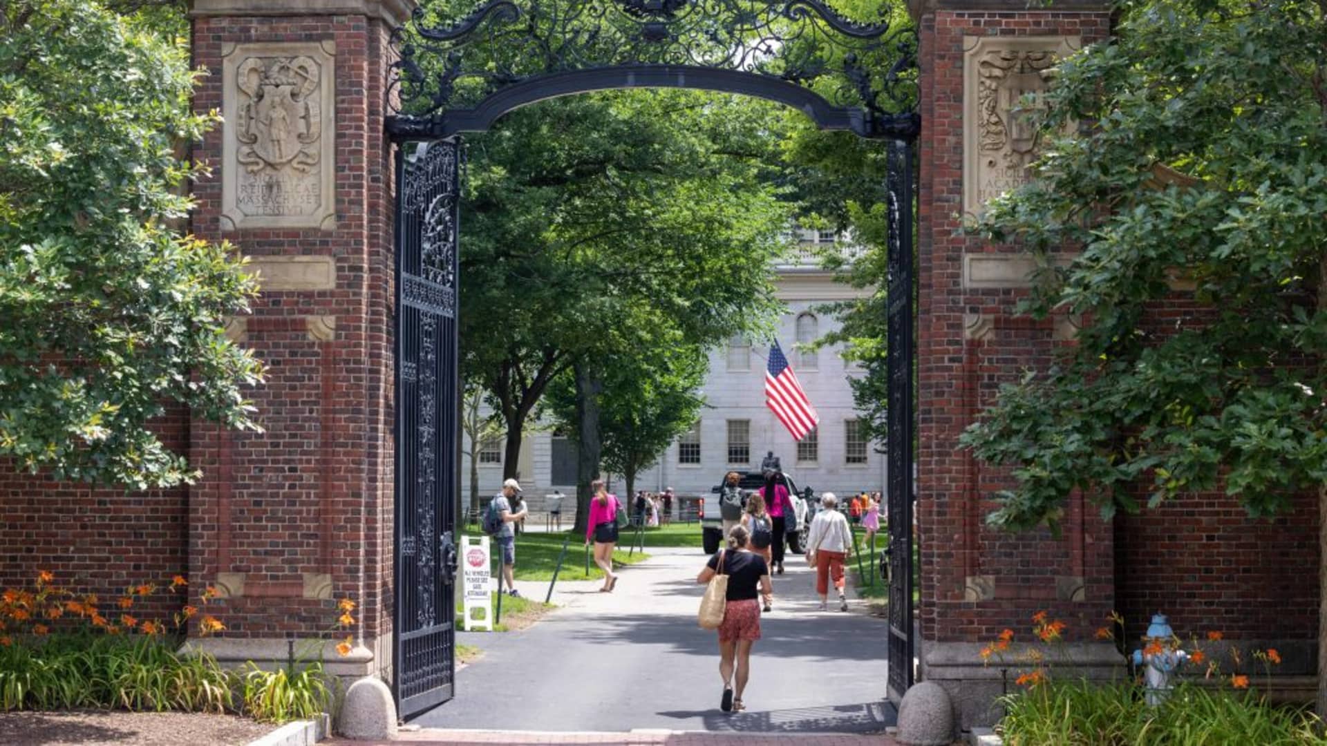 People walk through the gate on Harvard Yard at the Harvard University campus in Cambridge, Massachusetts, on June 29, 2023.
