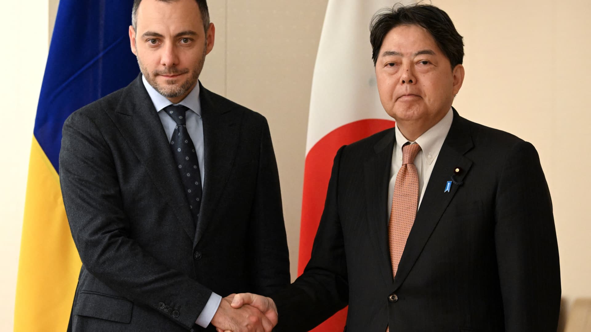 Oleksandr Kubrakov (L), Deputy Prime Minister for the restoration of Ukraine, shakes hands with Japan's Foreign Minister Yoshimasa Hayashi at the foreign ministry in Tokyo on June 19, 2023.