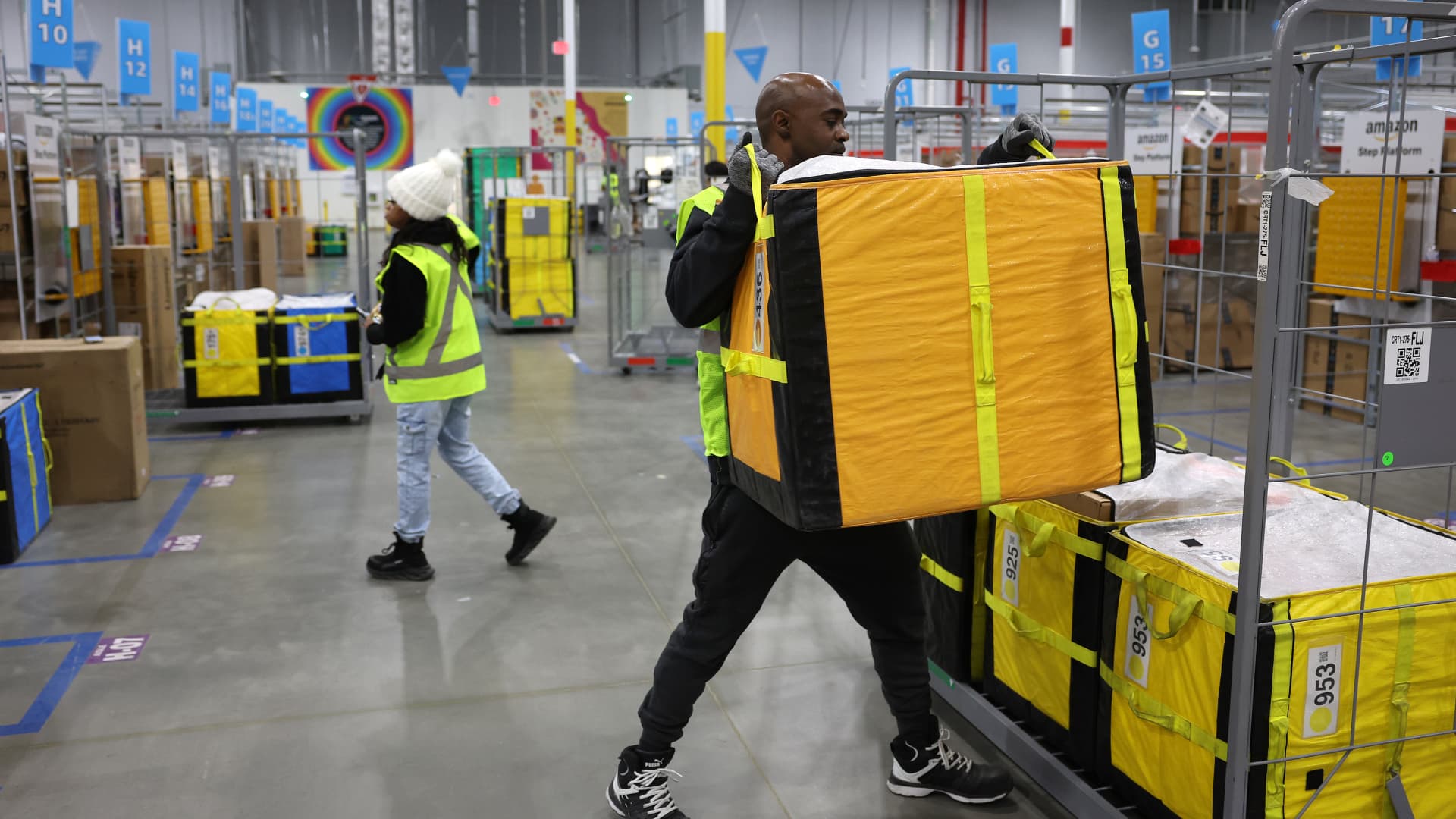 An Amazon worker moves a package onto a cart at an Amazon delivery station on November 28, 2022 in Alpharetta, Georgia.