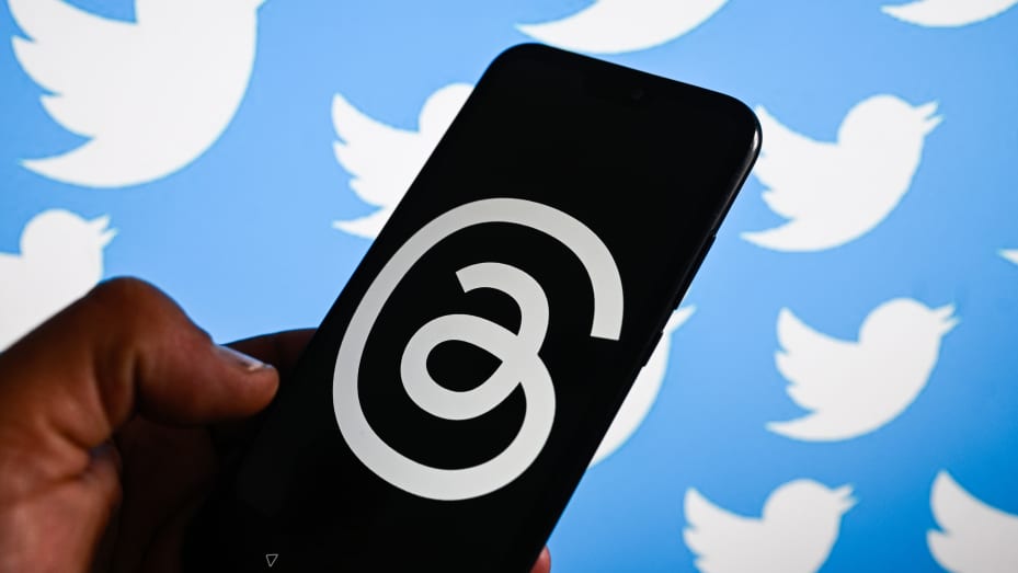  the Threads logo by META is displayed on a smartphone with Twitter logo in the background.
