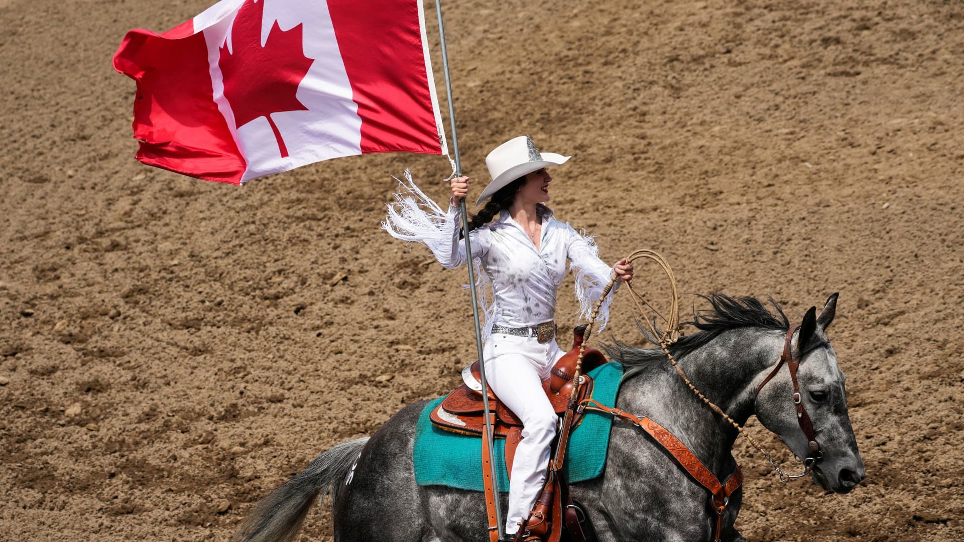 A Calgary Stampede Princess carries the Canadian flag at the start of the Calgary Stampede rodeo and exhibition, in Calgary, Alberta, Canada July 10, 2023.
