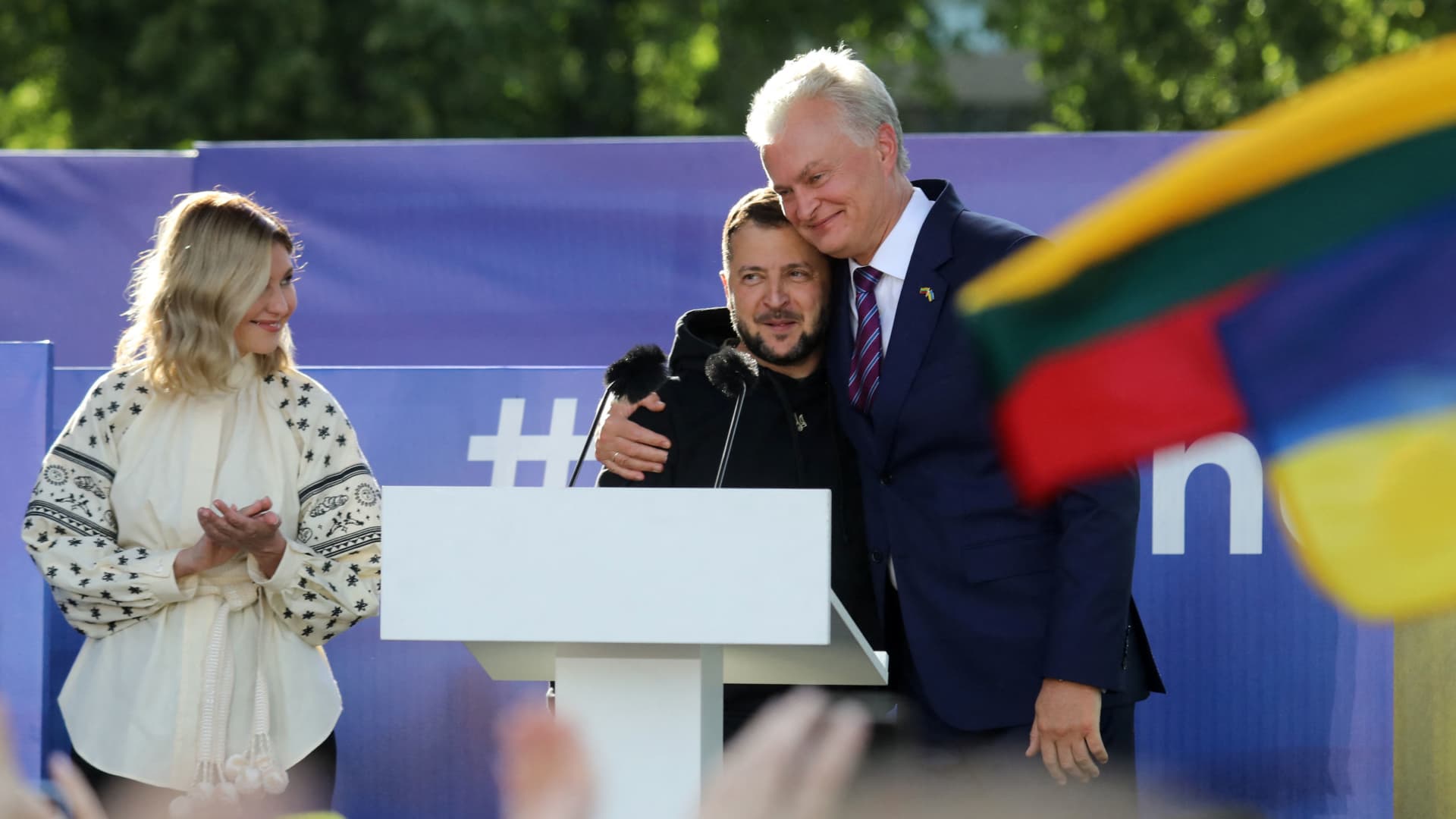 Ukrainian President Volodymyr Zelensky (C) gets a hug by Lithuania's President Gitanas Nauseda after addressing the crowd at Lukiskiu Square in Vilnius on July 11, 2023, during a NATO Summit. 
