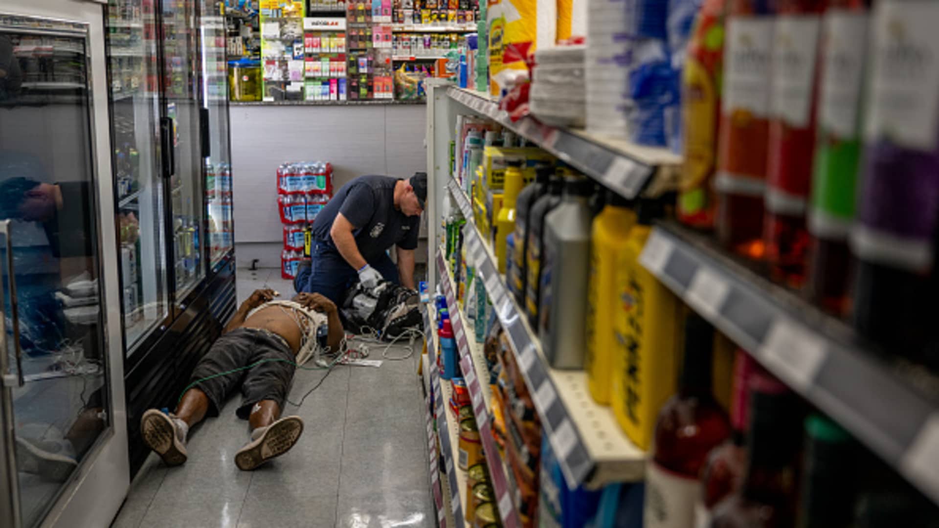 A person receives medical attention after collapsing in a convenience store on July 13, 2023 in Phoenix, Arizona. EMT was called after the person said they experienced hot flashes, dizziness, fatigue and chest pain. Record-breaking temperatures continue soaring as prolonged heatwaves sweep across the Southwest.