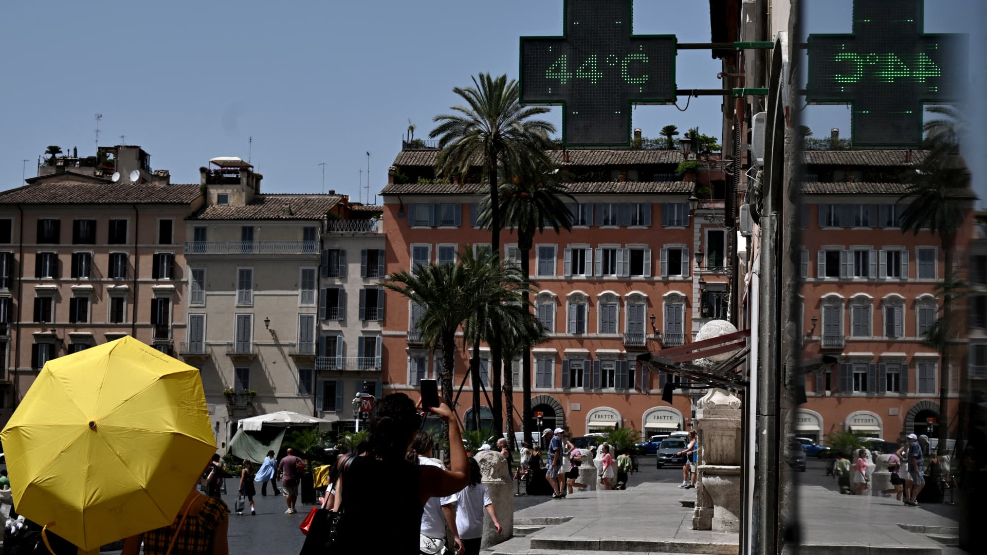 Pedestrians walk under a pharmacy's sign indicating the current outside temperature near the Scalinata di Trinita dei Monti (Spanish Steps) in Rome on July 17, 2023, during a heatwave in Italy.