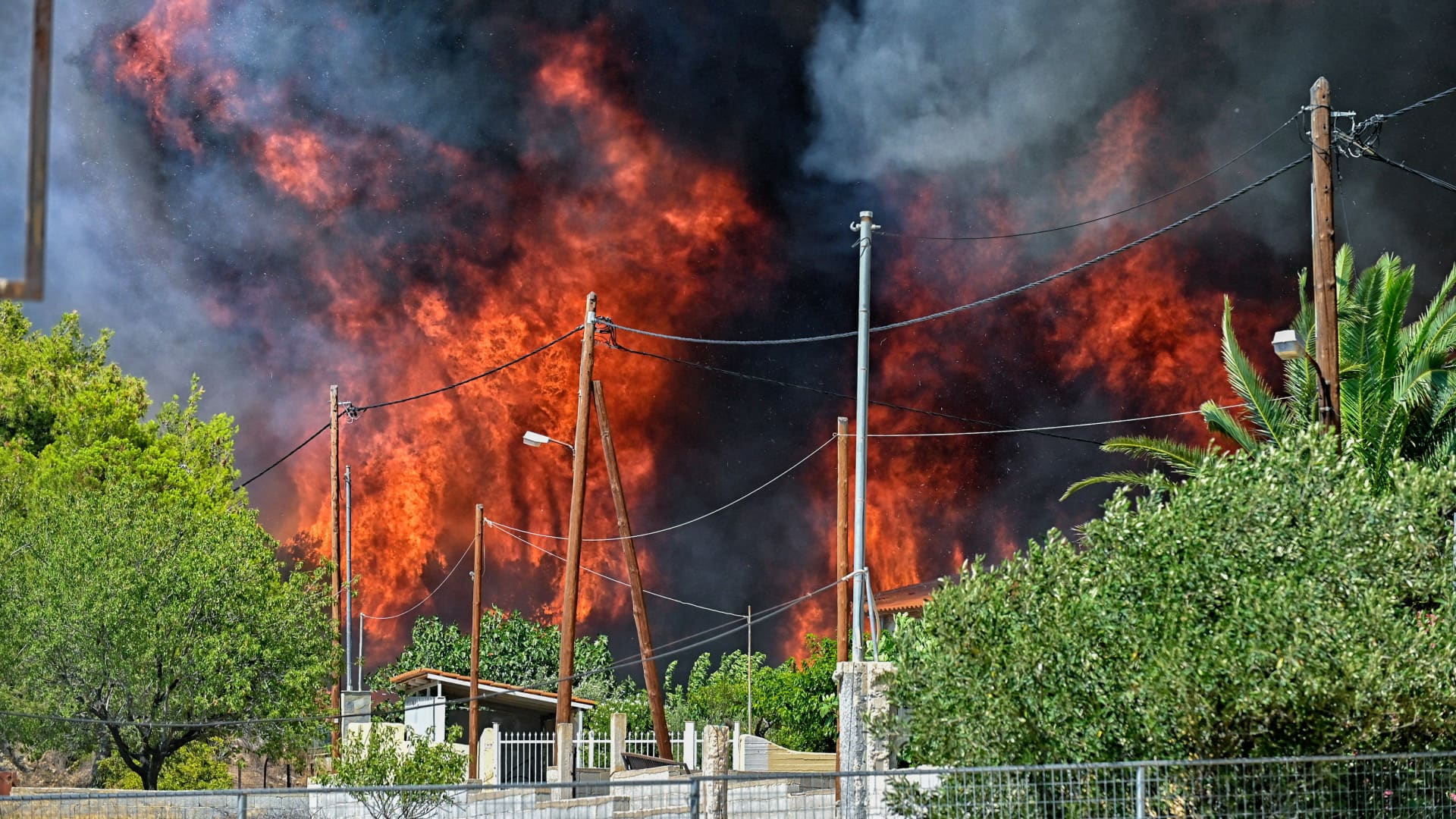 Wildfire rages by the houses in the settlement of Irini, near the resort town of Loutraki, some 80 kilometres east of Athens, on July 17, 2023.
