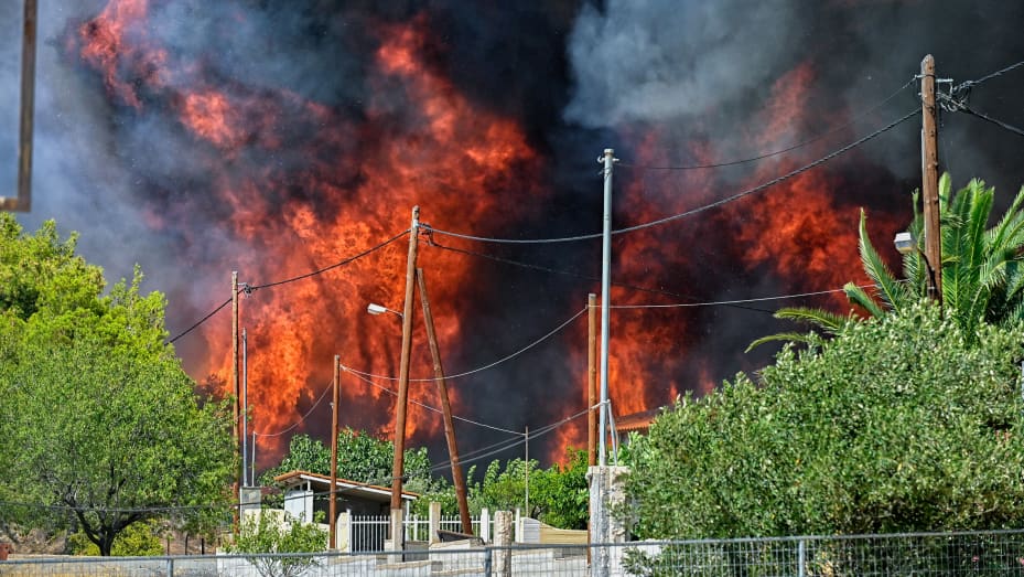 TOPSHOT - Wildfire rages by the houses in the settlement of Irini, near the resort town of Loutraki, some 80 kilometres east of Athens, on July 17, 2023. Greek police on July 17, 2023 arrested a man suspected of starting an ongoing wildfire near Athens fuelled by a heatwave and strong winds, firefighters said.
"Police carried out the arrest of a foreigner who allegedly caused the fire" in Kouvaras, around 50 kilometres (30 miles) southeast of Athens, said fire service spokesman Yannis Artopios. (Photo by Va