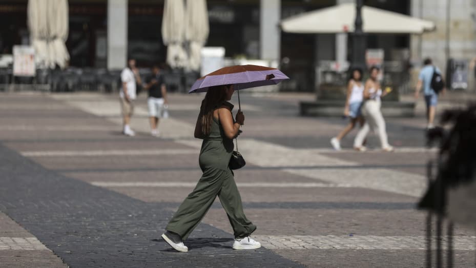 A woman walks with an umbrella at Plaza Mayor during the elections campaign as Spain faces another heatwave on July 19, 2023 in Madrid, Spain.
