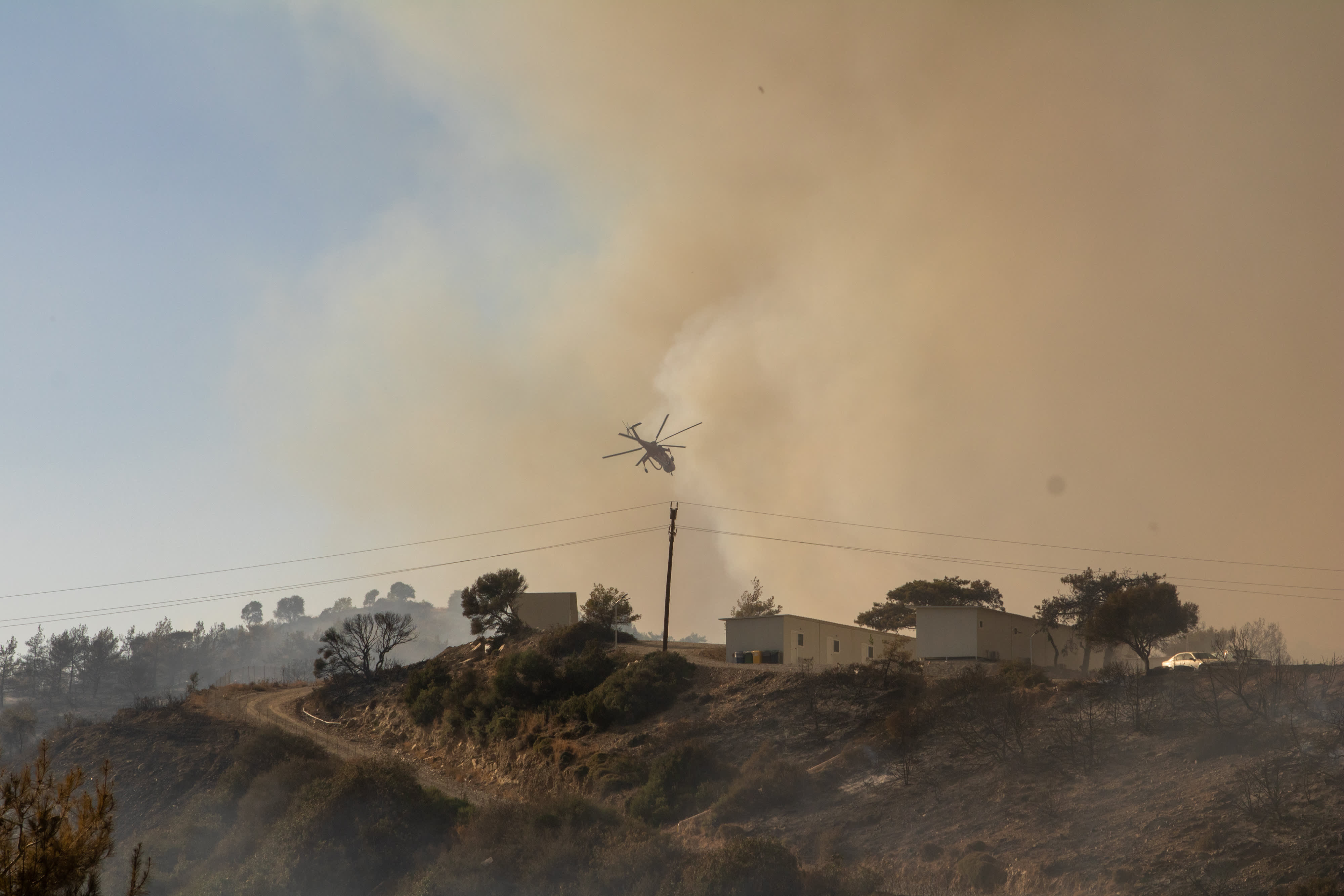 Turistas huyen de los incendios forestales en la isla griega de Rodas, miles evacuados