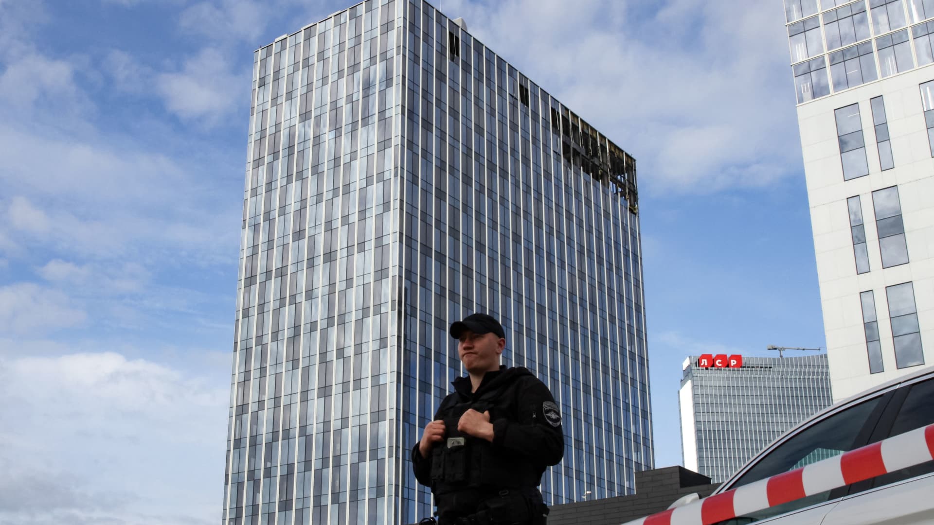 A police officer stands guard in front of a damaged business centre on Likhacheva Street after a reported drone attack in Moscow on July 24, 2023. (Photo by STRINGER / AFP) (Photo by STRINGER/AFP via Getty Images)