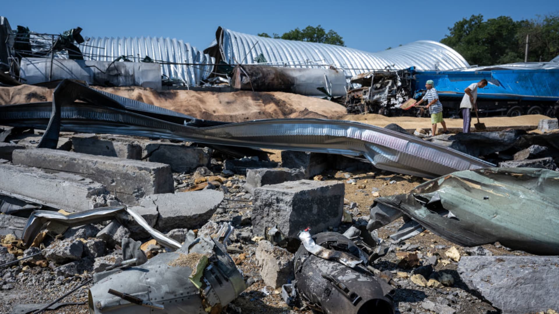 Remnants of Russian missiles lie in the foreground of wreckage as Ukrainians salvage barley and peas three days after five Russian missiles struck a grain storage facility in the village of Pavlivka, Odesa region, Ukraine, on July 24, 2023. 