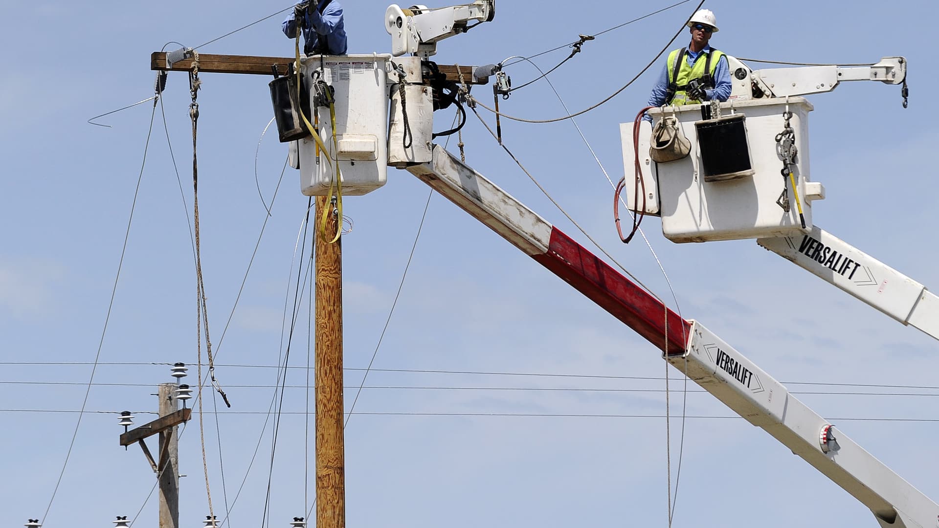 Electric company employees work to restore power in a tornado devastated neighborhood on May 22, 2013 in Moore, Oklahoma.