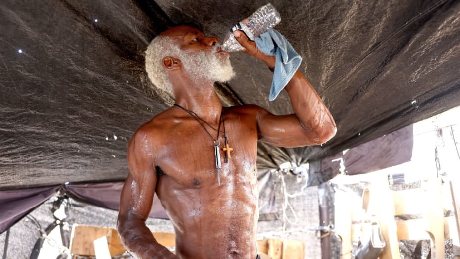 PHOENIX, ARIZONA - JULY 25: Rick White drinks water while cooling down in his tent in a section of the 'The Zone', Phoenix's largest homeless encampment, amid the city's worst heat wave on record on July 25, 2023 in Phoenix, Arizona. White said, 'The extreme heat is one thing, but the direct sun, it drains you quick...That sun will have you delirious.' While Phoenix endures periods of extreme heat every year, today is predicted to mark the 26th straight day of temperatures reaching 110 degrees or higher, a