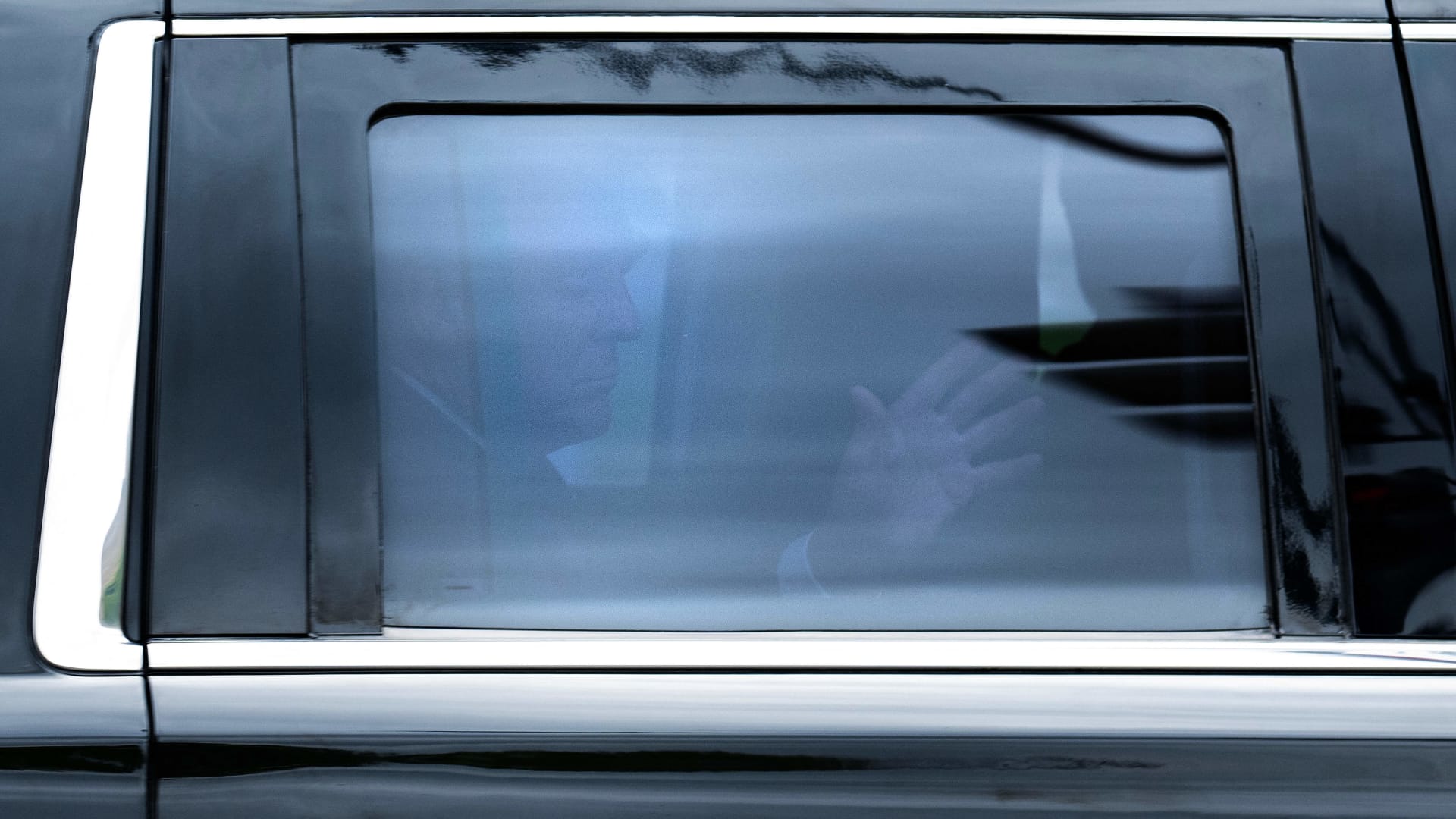 Former US President and 2024 hopeful Donald Trump waves from inside his SUV on his way to the E. Barrett Prettyman US Courthouse in Washington, DC, on August 3, 2023, ahead of his arraignment.