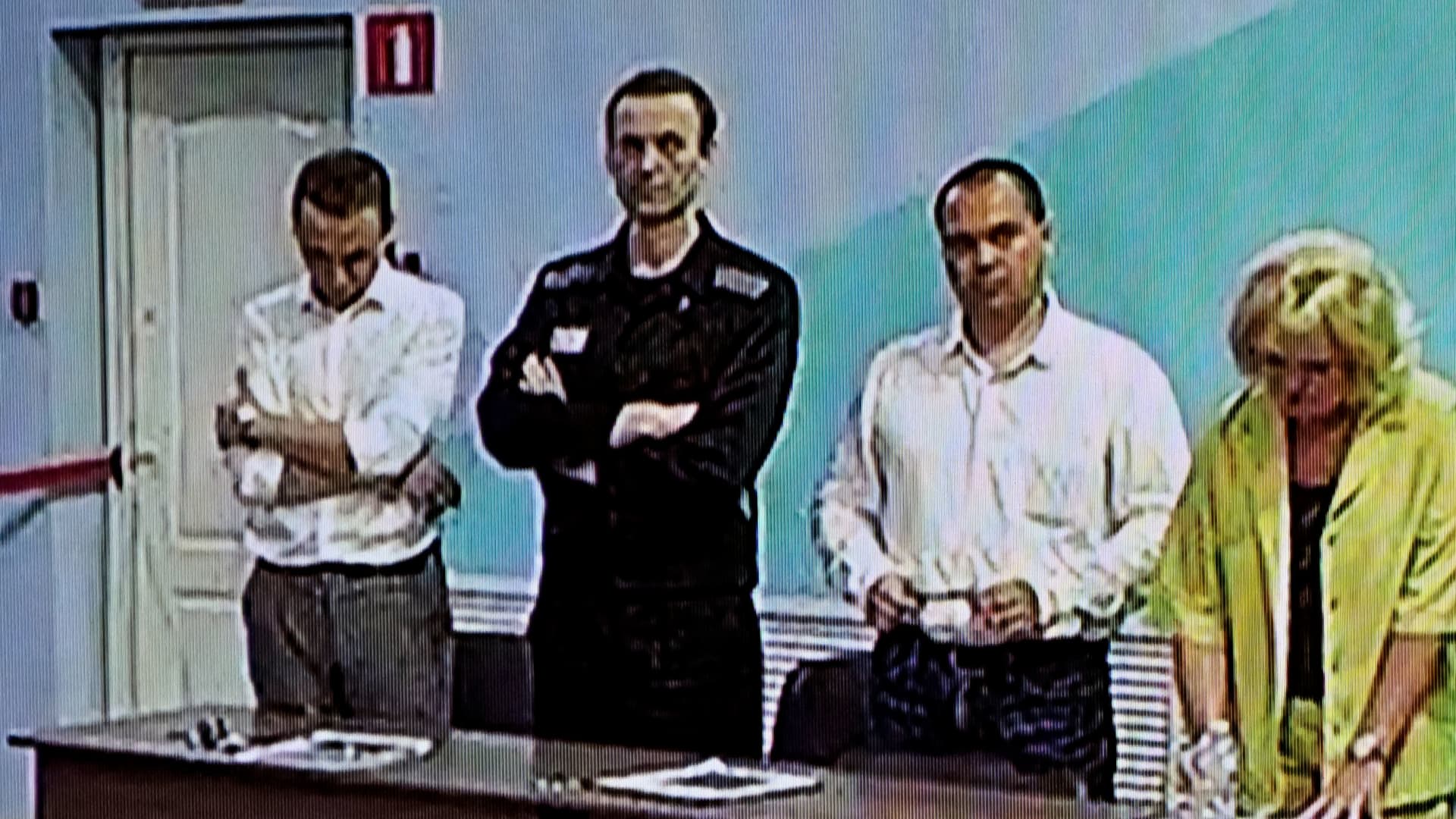 A screen shows the already imprisoned Russian opposition figure Alexei Navalny (2L) as he listens to his verdict over a series of extremism charges at the IK-6 penal colony, a maximum-security prison some 250 kilometres (155 miles) east of Moscow, in the settlement of Melekhovo in the Vladimir region on August 4, 2023.