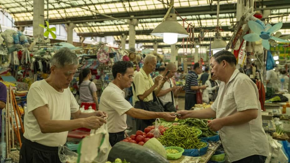 Clientes en un puesto de verduras en un mercado de alimentos frescos en Shanghái, China, el lunes 7 de agosto de 2023. China publicará sus cifras de crecimiento de los precios al consumidor el 9 de agosto, pero el problema del país es la deflación y no el crecimiento de los precios.  De hecho, las previsiones sugieren una desaceleración de gran alcance en la economía asiática, incluido el crecimiento del crédito y el comercio.  Fotógrafo: Raúl Ariano/Bloomberg vía Getty Images