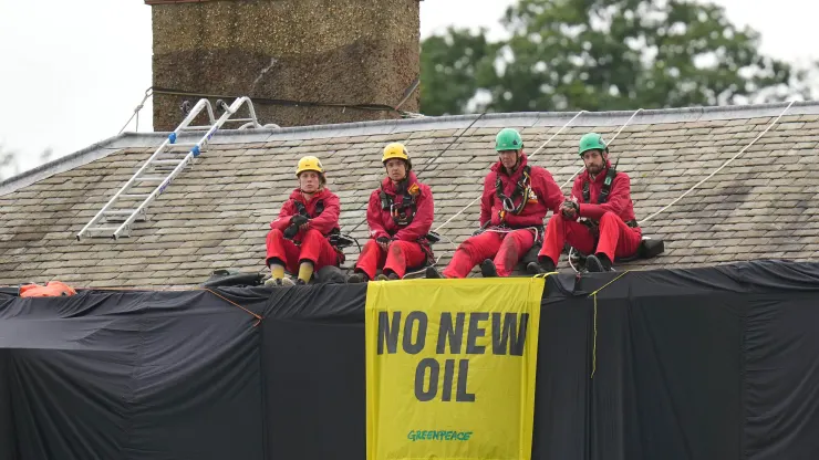 Greenpeace activists on the roof of U.K. Prime Minister Rishi Sunak's house in Richmond, North Yorkshire after covering it in black fabric in protest at his backing for expansion of North Sea oil and gas drilling.