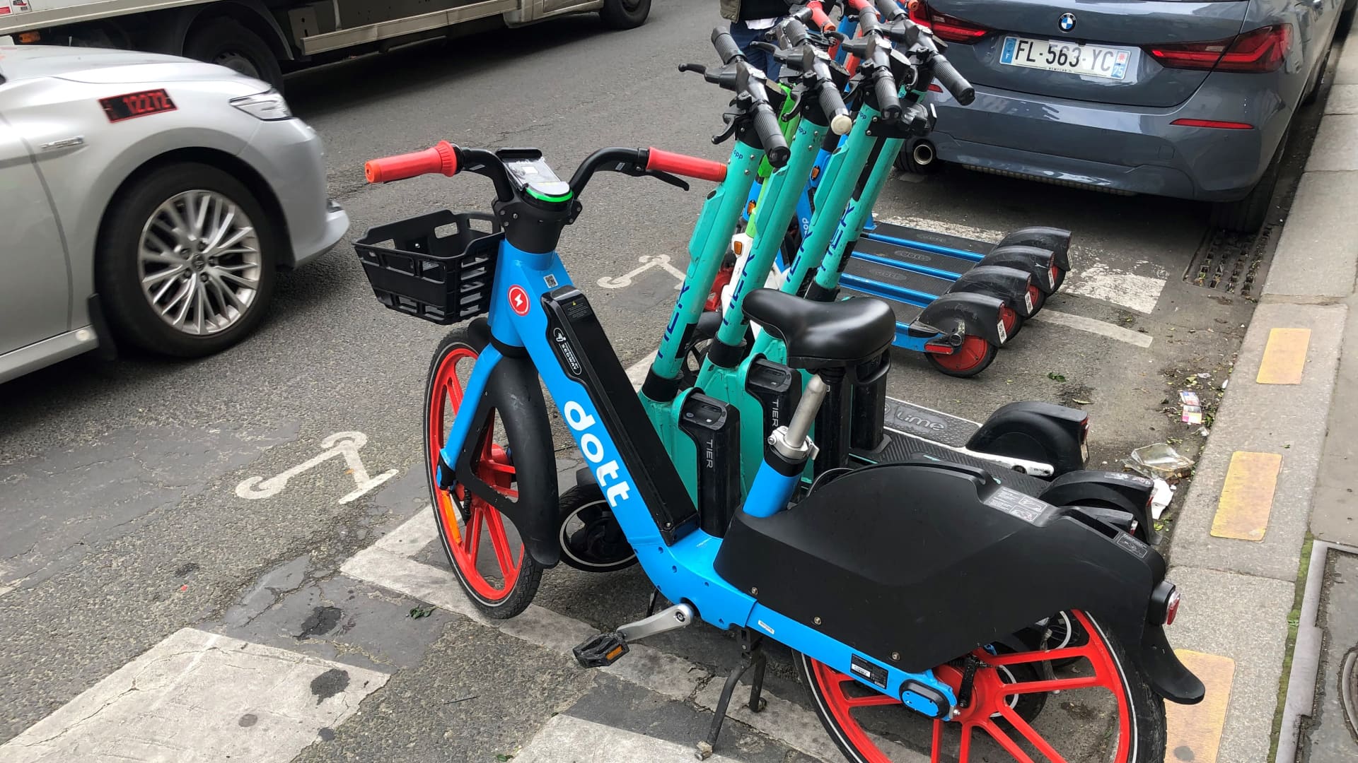 E-scooters and an e-bike are parked in a designated parking space.