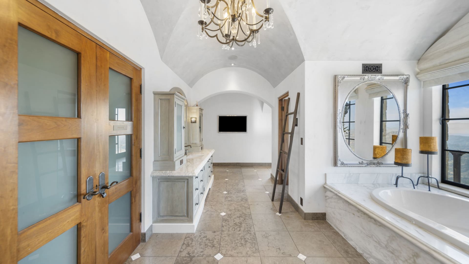 The primary suite's marble-clad bathroom and arched ceilings.