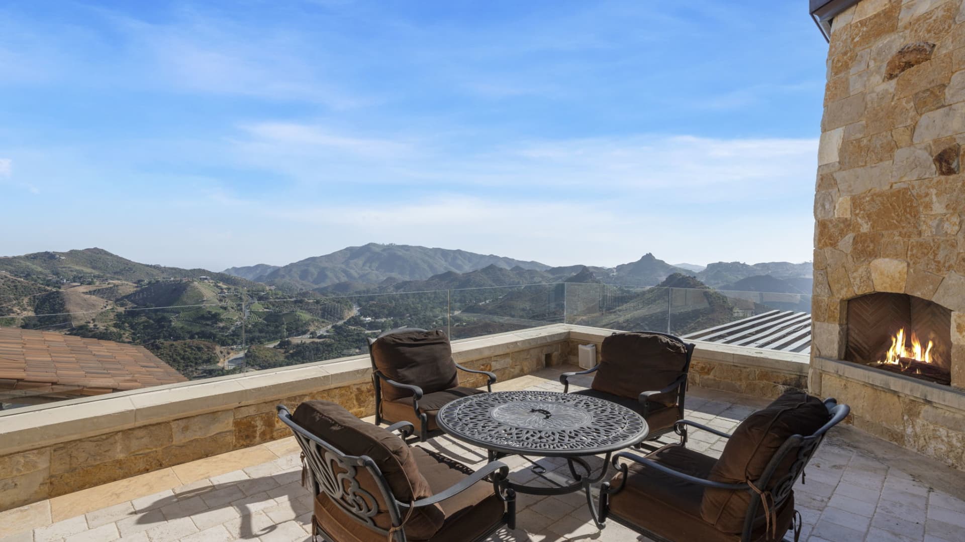 A terrace off the primary suite with a fireplace and views of the Santa Monica Mountains.