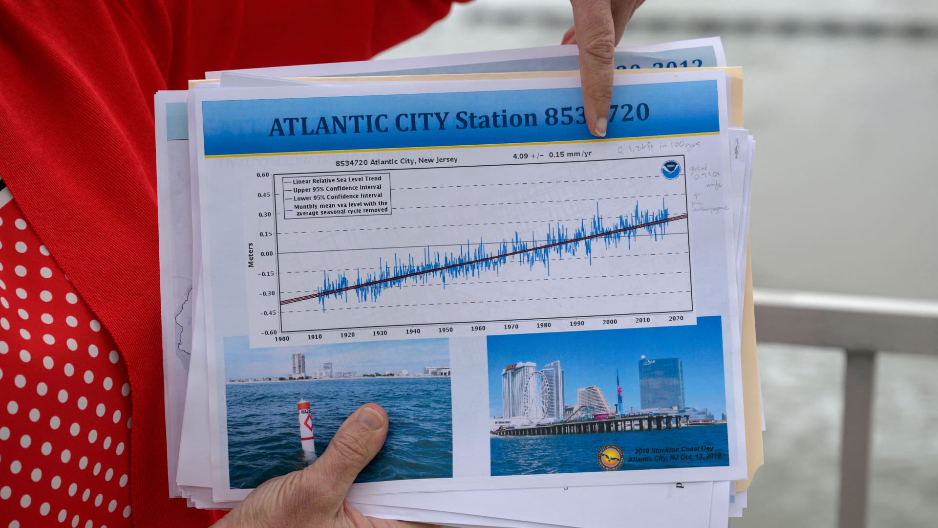Kimberly McKenna, Associate Director at Stockton University Coastal Research Center points at a graph indicating rising sea levels in Atlantic City, New Jersey on October 26, 2022. Ten years after the devastating hurricane Sandy, the seaside town of Atlantic City, on the American east coast, has fortified its famous promenade between its casinos and the Atlantic Ocean. But behind the beaches, for the inhabitants of certain neighborhoods, the flooded streets are almost part of everyday life.