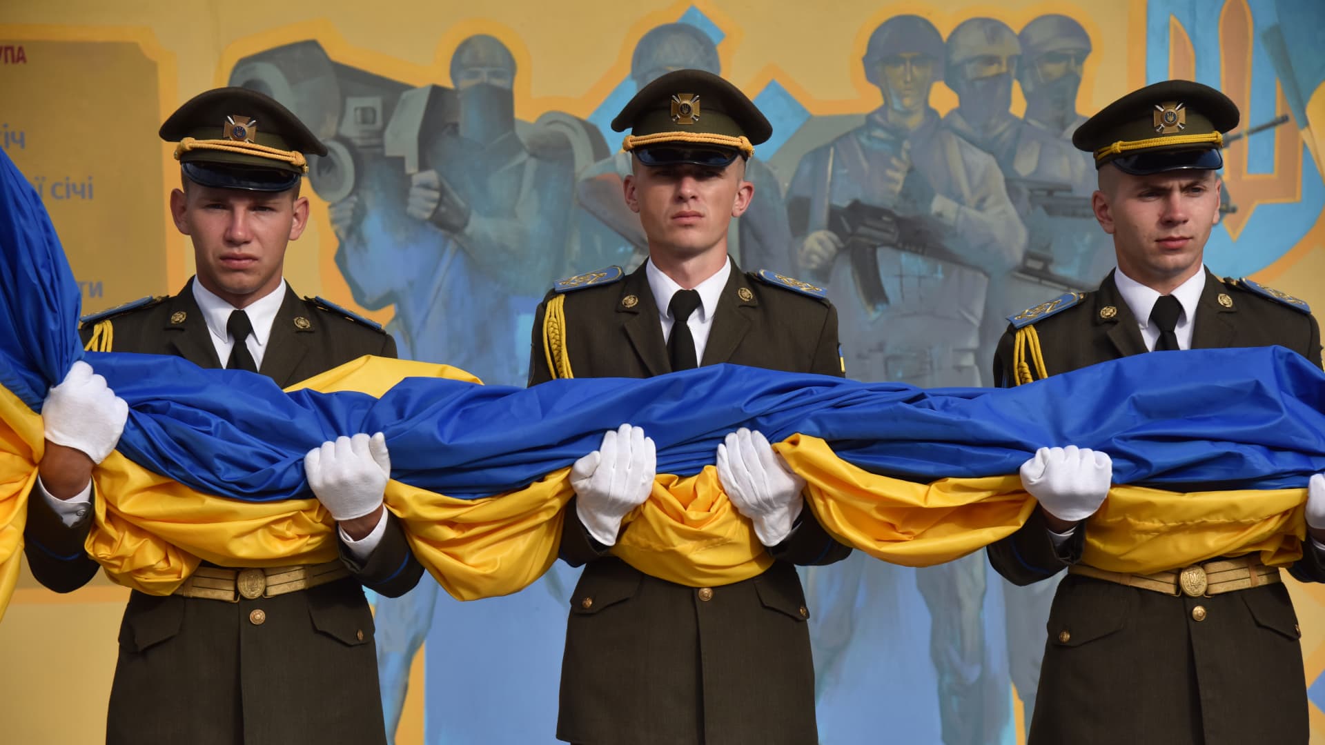 Military personnel hold the edge of the flag so it doesn't touch the ground during the ceremony of raising the Ukrainian flag on the largest flagpole in the city within the celebrations of the National Flag Day of Ukraine in Lviv, Ukraine on August 23, 2023. 