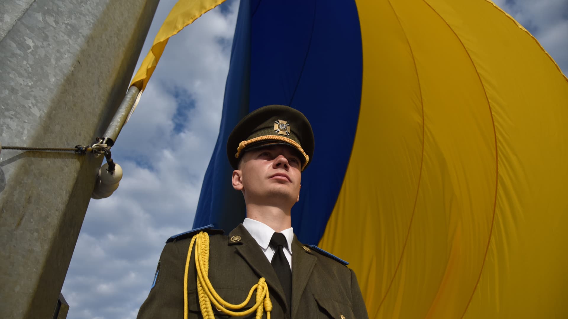 A military member in a moment of silence during the ceremony of raising the Ukrainian flag on the largest flagpole in the city within the celebrations of the National Flag Day of Ukraine in Lviv, Ukraine on August 23, 2023.