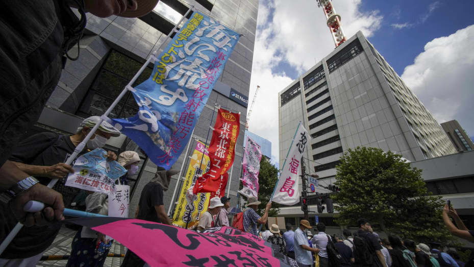 Los manifestantes sostienen carteles que dicen "¡No arrojen agua contaminada radiactiva al mar!"  mientras participan en una manifestación frente al edificio de la sede de la Compañía de Energía Eléctrica de Tokio (TEPCO) en Tokio el 24 de agosto de 2023, contra el plan del gobierno japonés de liberar al océano las aguas residuales tratadas de la averiada central eléctrica de Fukushima-Daiichi.  (Foto de Kazuhiro NOGI/AFP) (Foto de KAZUHIRO NOGI/AFP vía Getty Images)