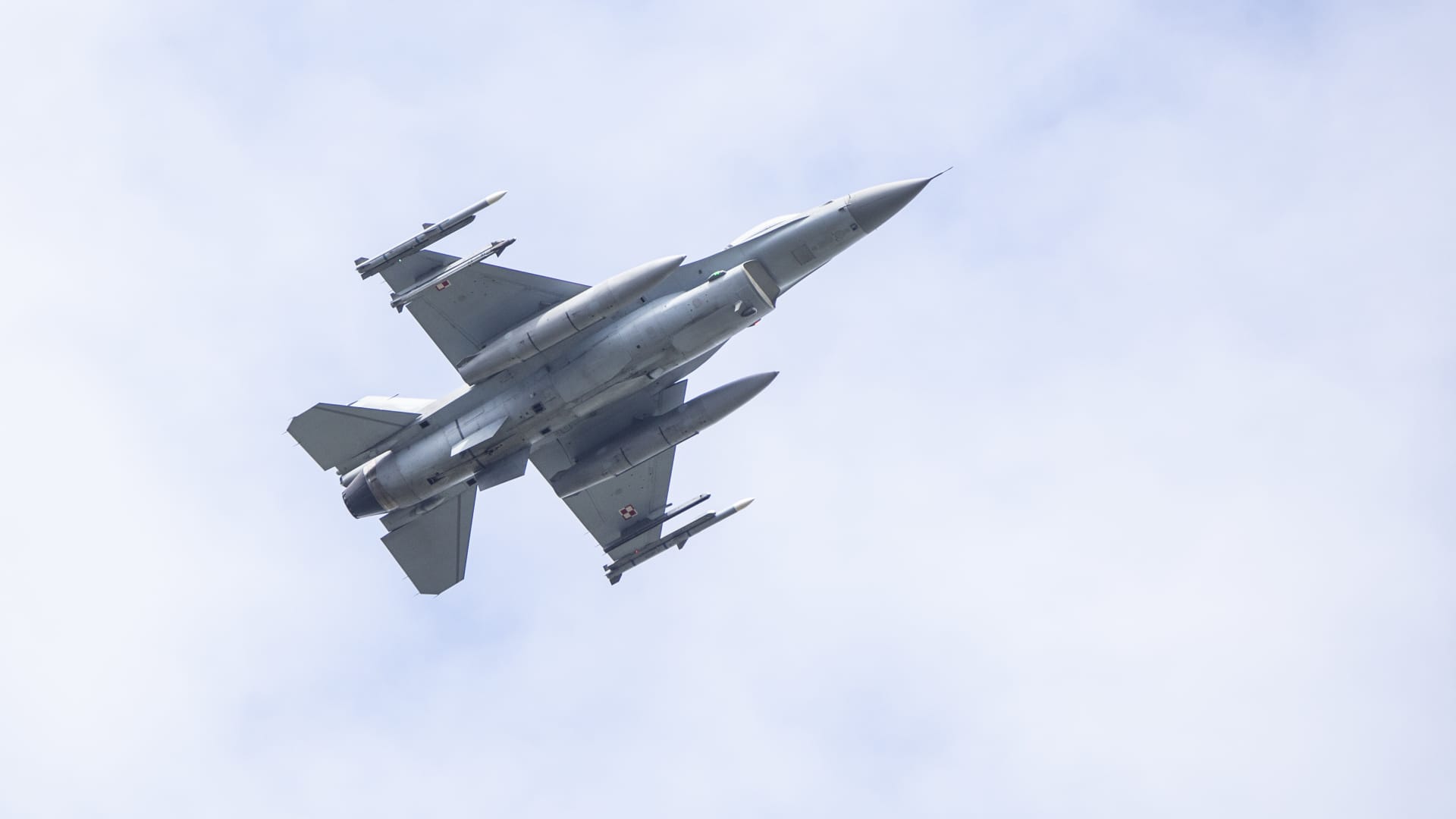 F-16 fighter jet flying during a military parade in Warsaw.
