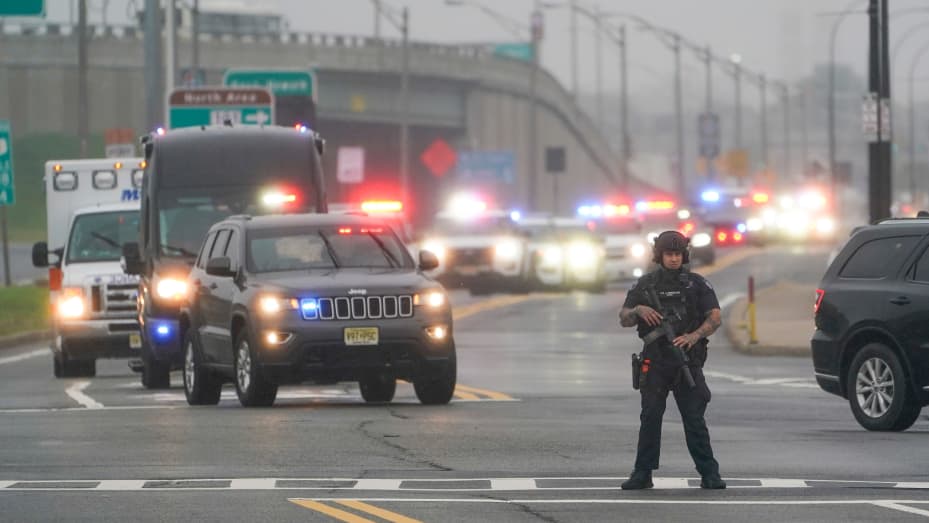 A police officers stands in the road as a motorcade for former President Donald Trump arrives to Newark Liberty International Airport in Newark, N.J., Thursday, Aug. 24, 2023.