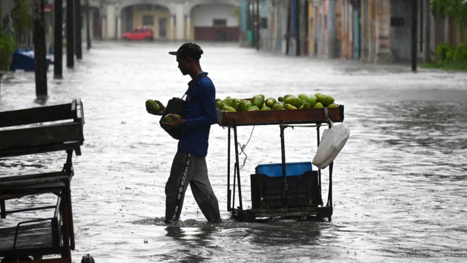 Un hombre vende frutas en una calle inundada de La Habana, el 29 de agosto de 2023, durante el paso de la tormenta tropical Idalia.