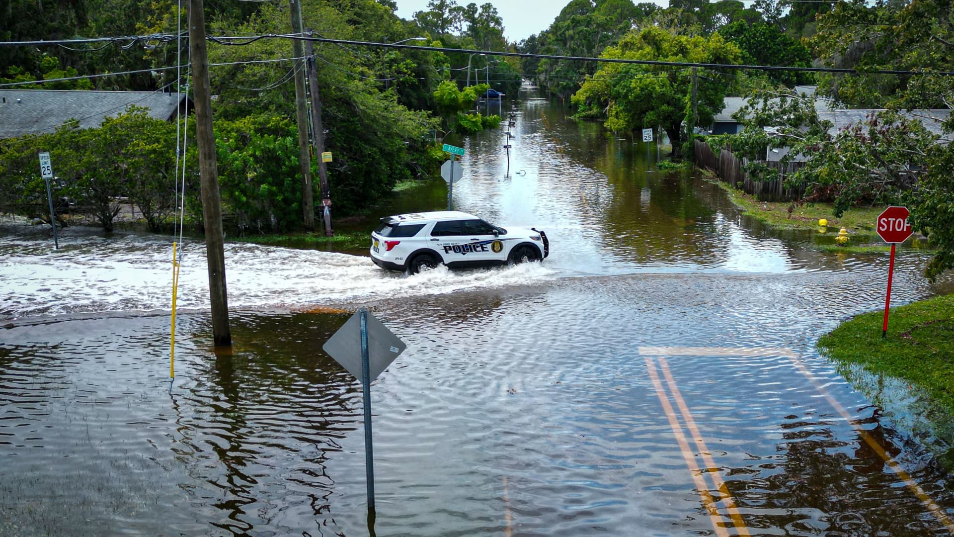 An aerial view shows a police vehicle driving along a flooded street in New Port Richey, Florida, on August 30, 2023, after Hurricane Idalia made landfall.