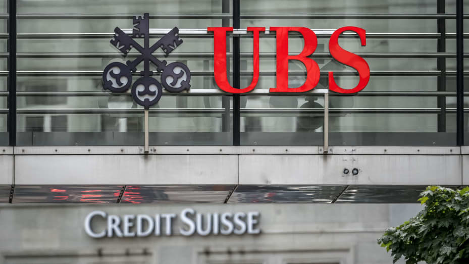 Sobre un cartel del Credit Suisse en Zúrich se ve un cartel del gigante bancario suizo UBS.