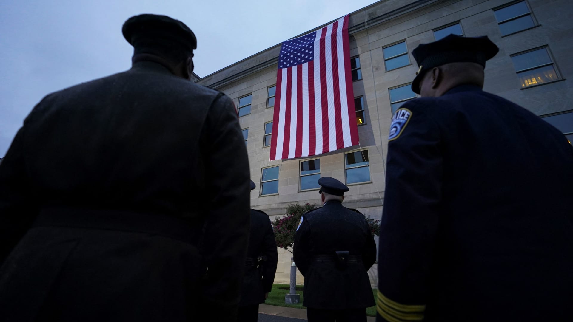 First responders watch as a U.S. flag is unfurled from the roof of the Pentagon to mark the 22nd anniversary of the terrorist attacks of Sept. 11, 2001.
