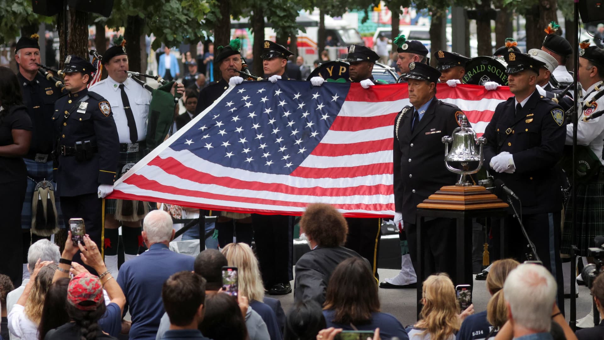 First responders hold a U.S. flag during the bell-ringing ceremony on the 22nd anniversary of the 9/11 attacks at the National September 11 Memorial & Museum in New York City, Sept. 11, 2023.