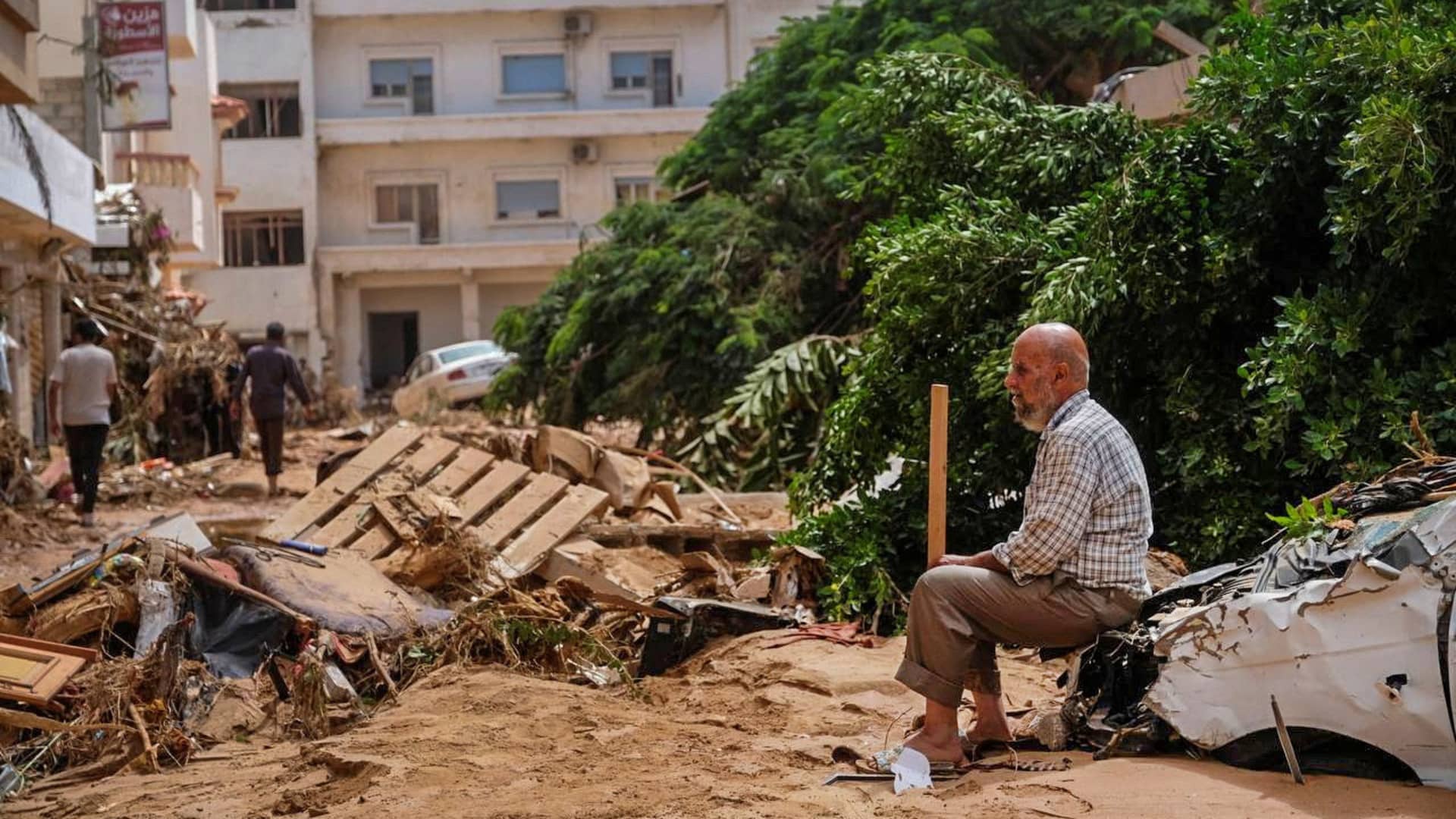 A man sits on a damaged car, after a powerful storm and heavy rainfall hit Libya, in Derna, Libya September 12, 2023.