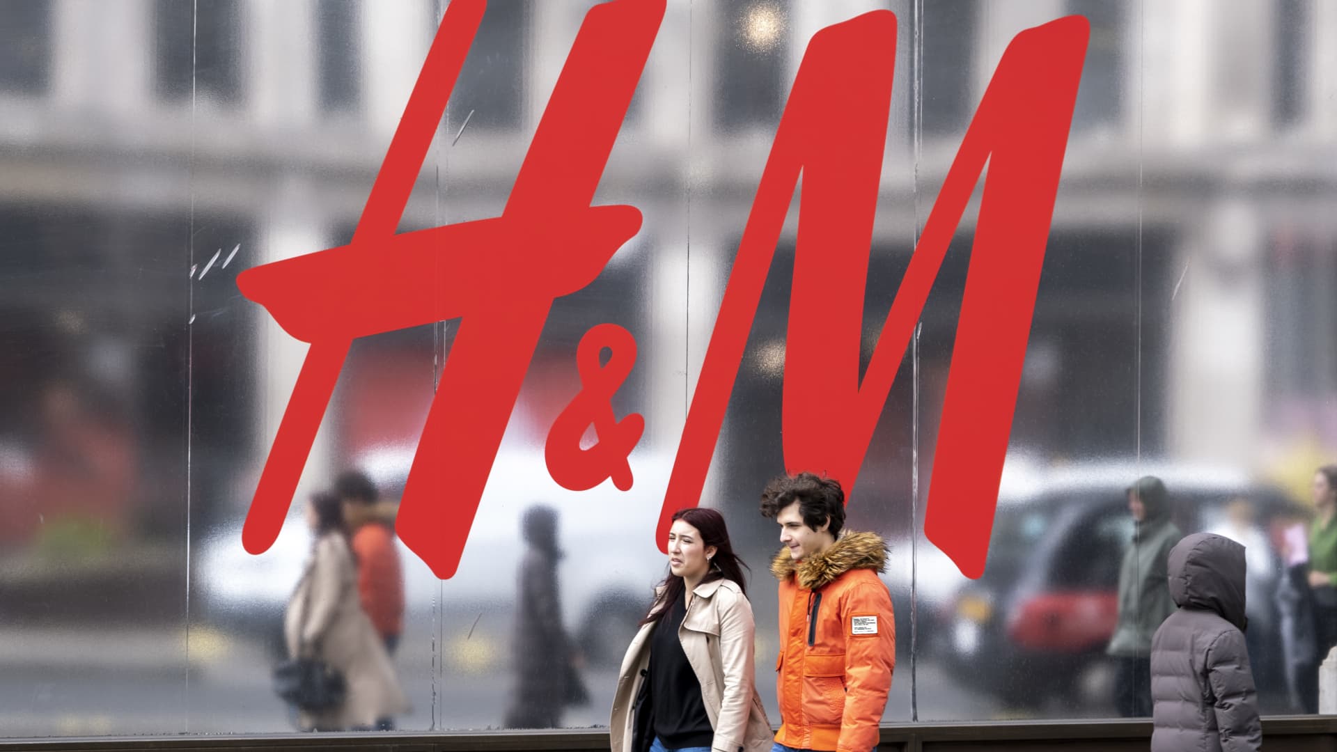 People passing a large-scale sign for H&M outside its flagship store on the corner of Oxford Street and Regent Street in London, U.K., on March 30, 2023.