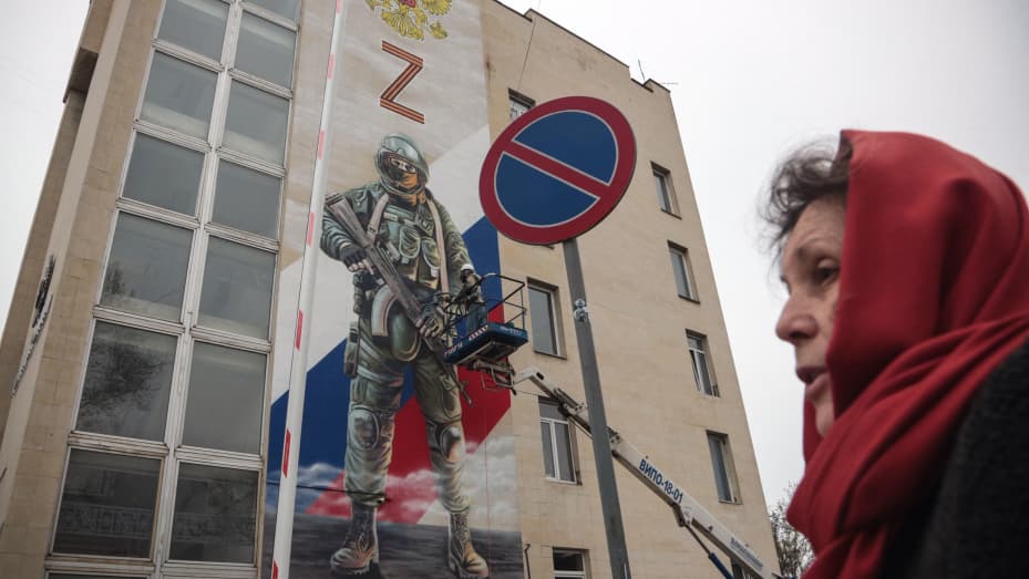 A woman walks past a huge poster depicturing a Russian soldier and a Z letter - a tactical insignia of Russian troops in Ukraine, in Sevastopol, Crimea, on April 23, 2022. The "Z", which has become a symbol of support for Russian military action in Ukraine, is widely used by Russian authorities and President Putin supporters, decorating building facades, bus doors, car windscreens and T-shirts.