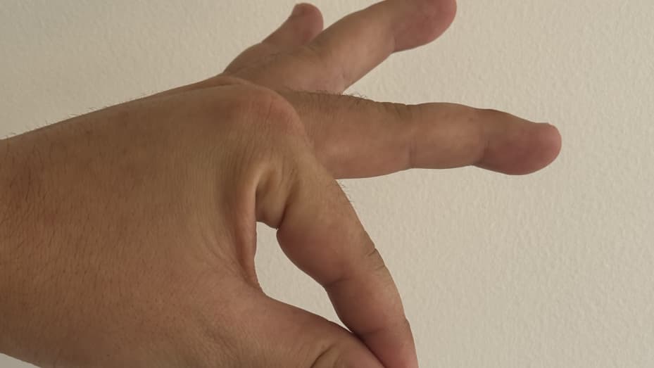 What the hand gesture looks like to do a double tap on Apple Watch Series 9.