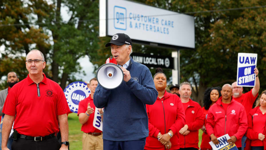 U.S. President Joe Biden speaks next to Shawn Fain, President of the United Auto Workers (UAW), as he joins striking members of the United Auto Workers (UAW) on the picket line outside the GM's Willow Run Distribution Center, in Bellville, Wayne County, Michigan, U.S., September 26, 2023. REUTERS/Evelyn Hockstein
