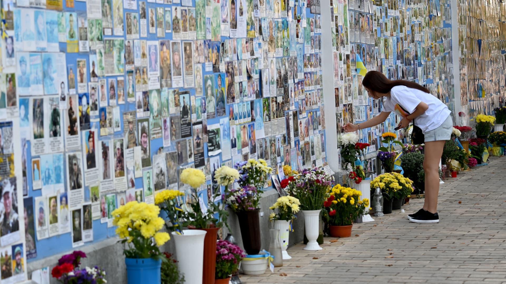 A girl touches a photograph of her relative on the Memory Wall of Fallen Defenders of Ukraine in the Russian-Ukrainian War in Kyiv on September 27, 2023. 