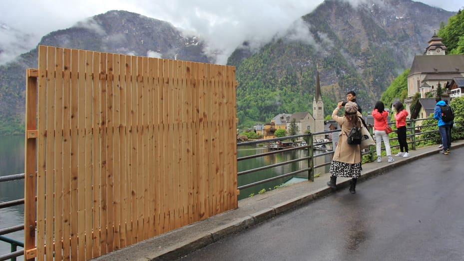 Signs urged visitors to stay "Quiet Please!" and a driving barrier was installed at Hallstatt's entrance before the Austrian town built a fence at a popular lookout point.