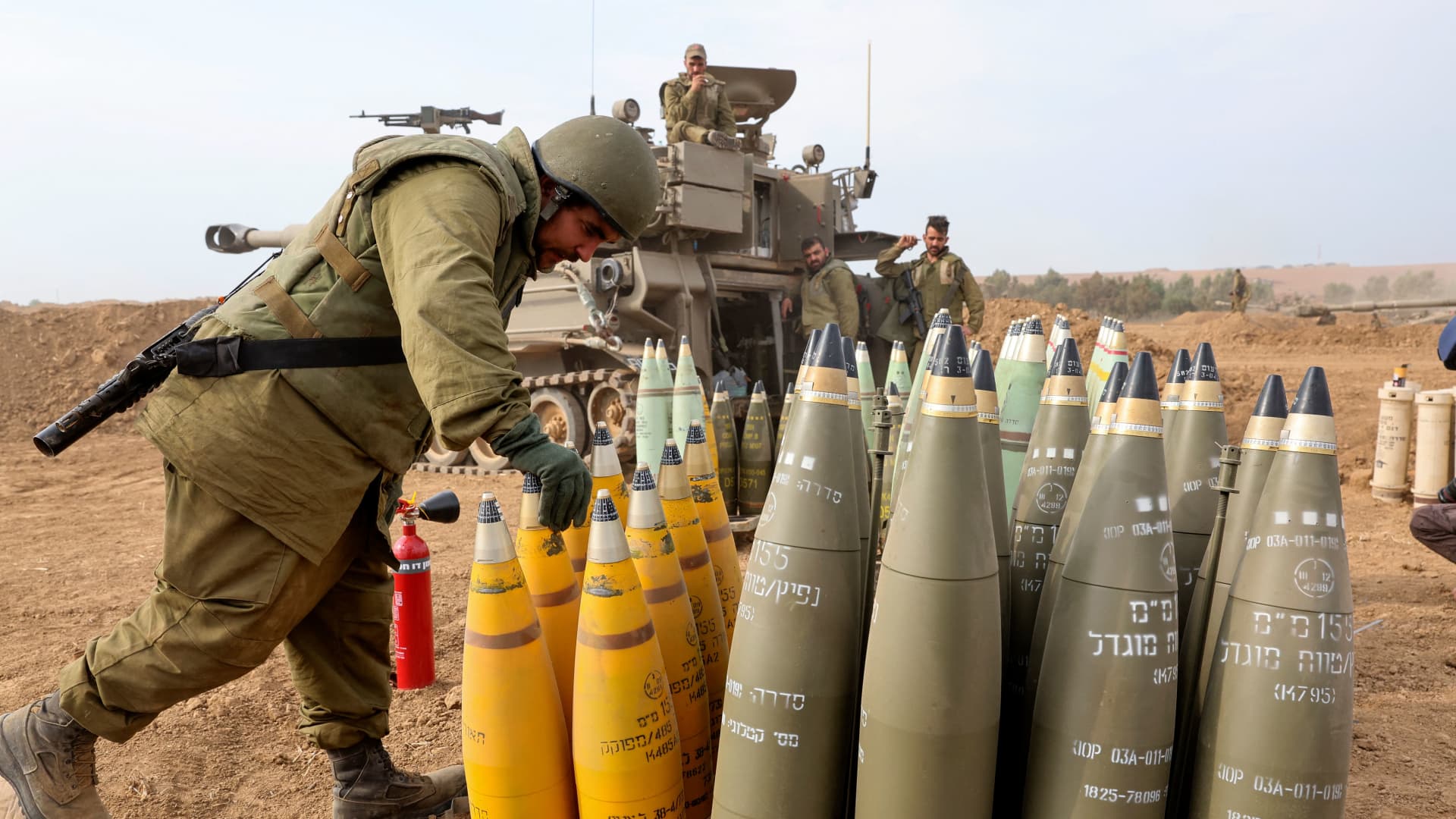 An Israeli soldier arranges artillery shells on the border with Gaza in southern Israel on October 9, 2023. 