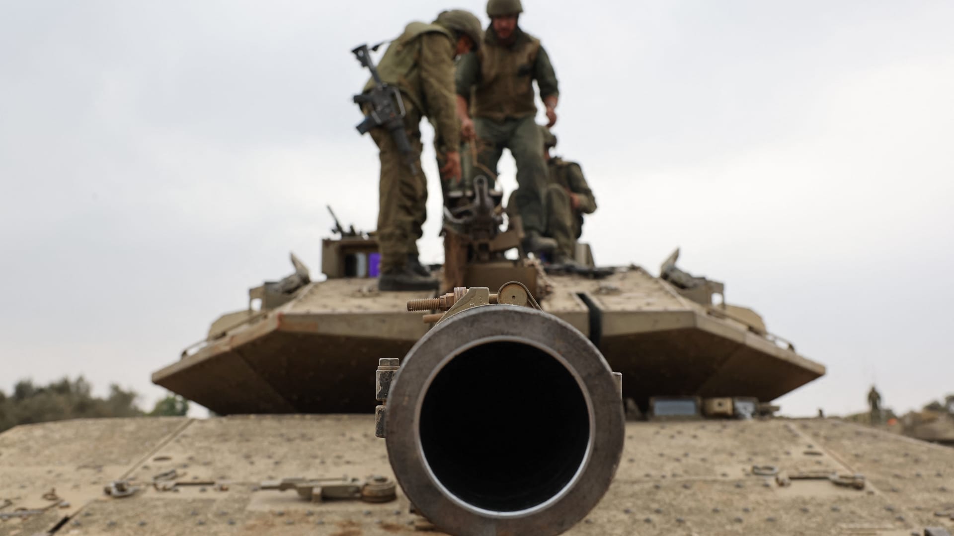 Israeli army soldiers are positioned with their Merkava tanks near the border with the Gaza Strip in southern Israel on October 9, 2023.